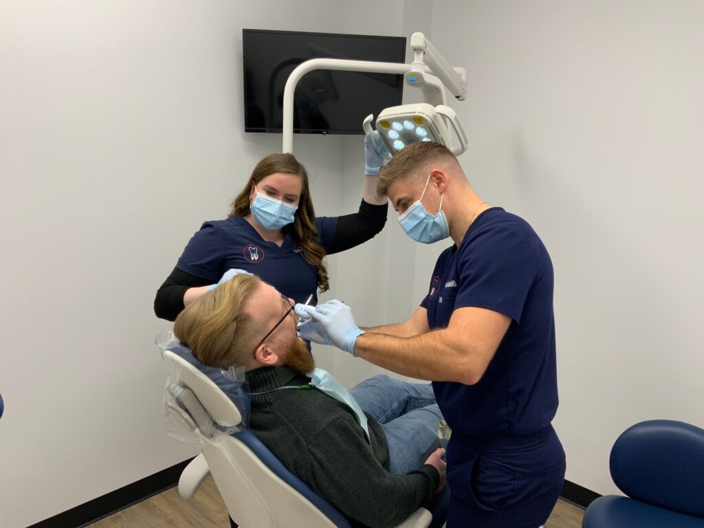 Two dentists examining a patient