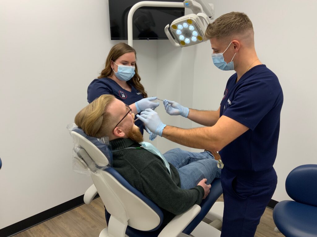 Two Dolan Dental clinicians examining a patient