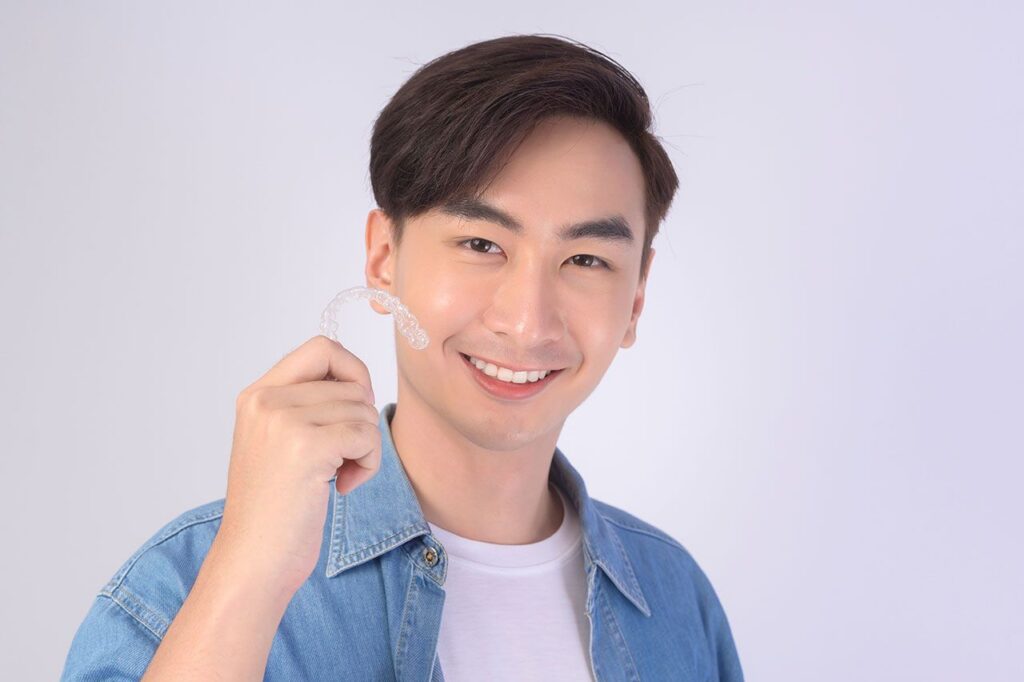 Patient holding a clear dental aligner