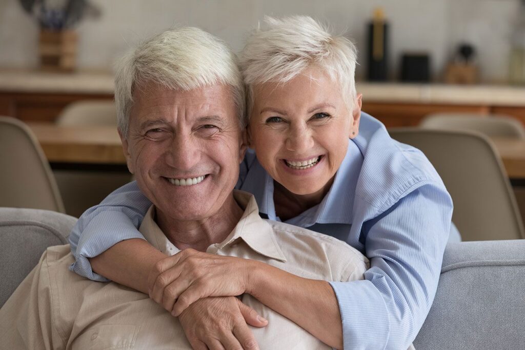 Older couple smiling together on a couch