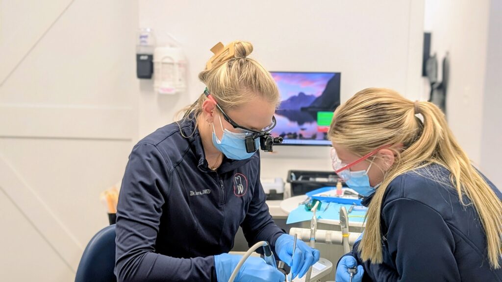 Two dental clinicians treating a patient
